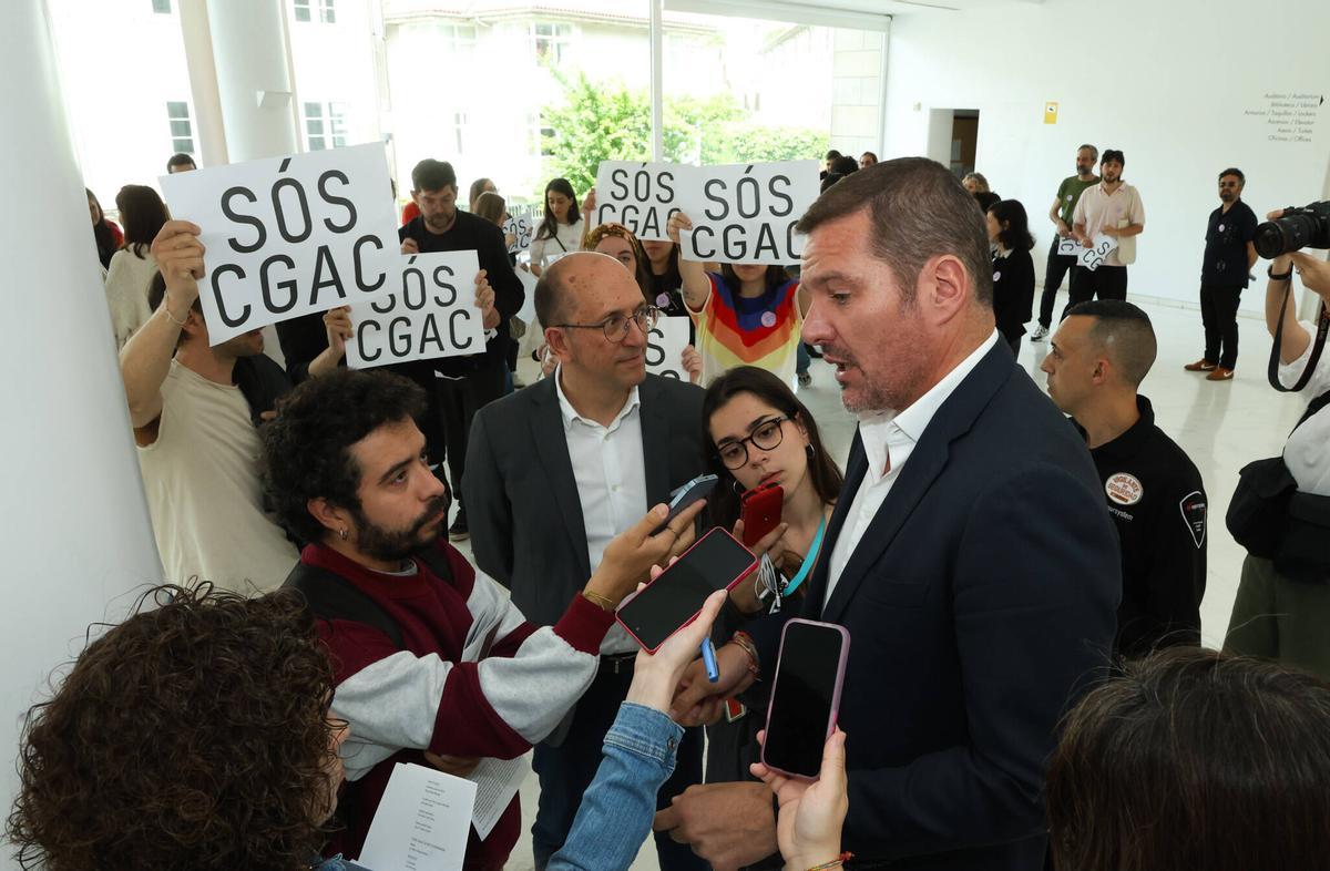 El conselleiro de Cultura y el director xeral de Cultura, rodeados de carteles de SóS CGAC.