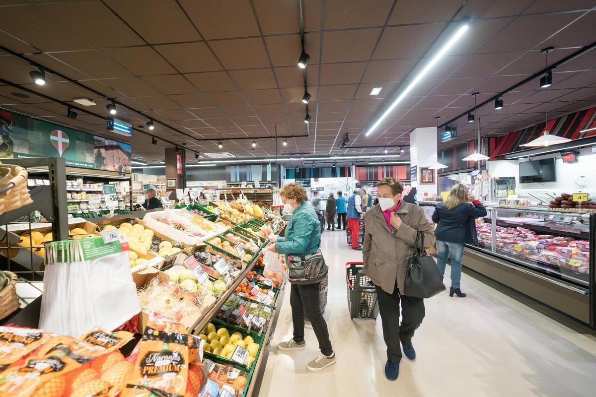 Varias personas realizan la compra en un supermercado.