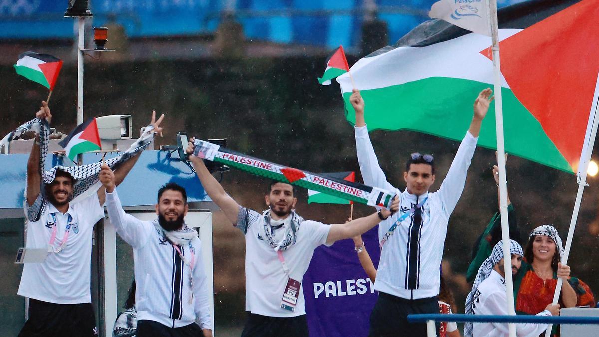 Los abanderados Wasim Abusal, Valerie Rose Tarazi y los atletas de Palestina en el desfile flotante por el río Sena durante la ceremonia de apertura de los Juegos Olímpicos de Paris 2024