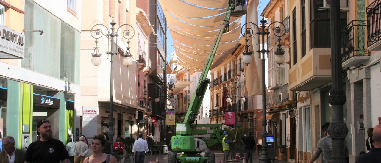 Operarios retirando los toldos de la calle Corredera a finales de octubre pasado.