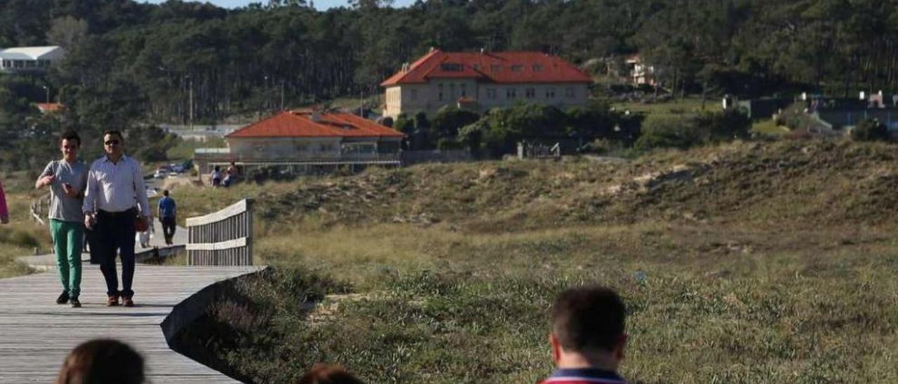 El edificio del hotel-restaurante, el de la pousada da Lanzada y los montes de San Vicente. // Muñiz