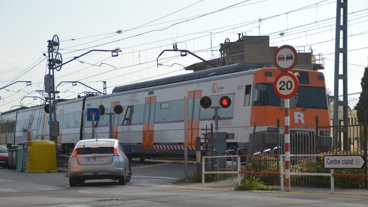 Un tren circulant pel pas a nivell del carrer dels Fossos de Figueres.