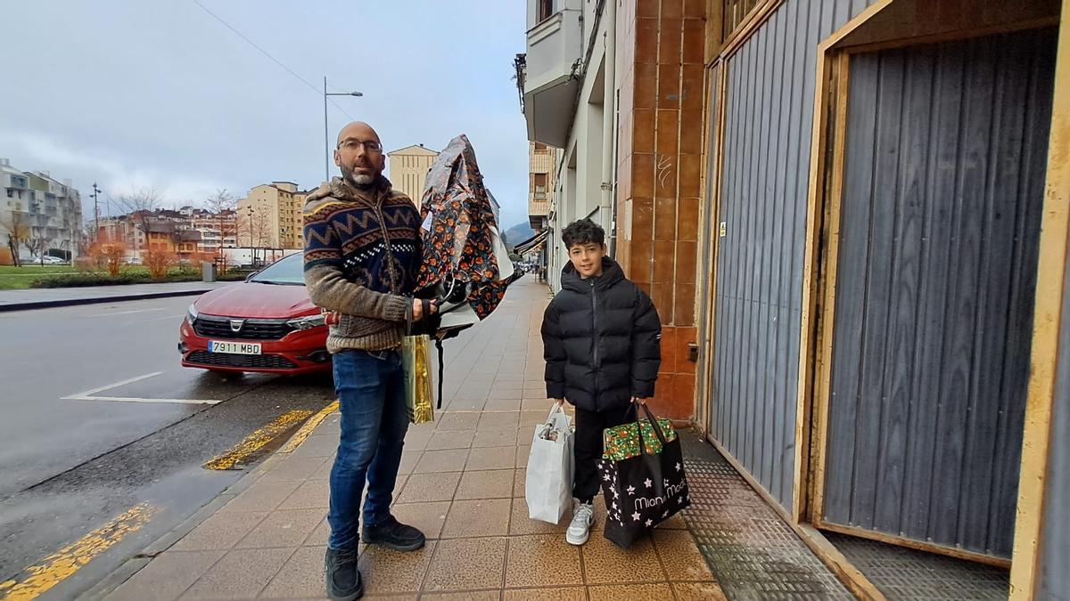 David López y su hijo Diego, ayer, cargados de regalos