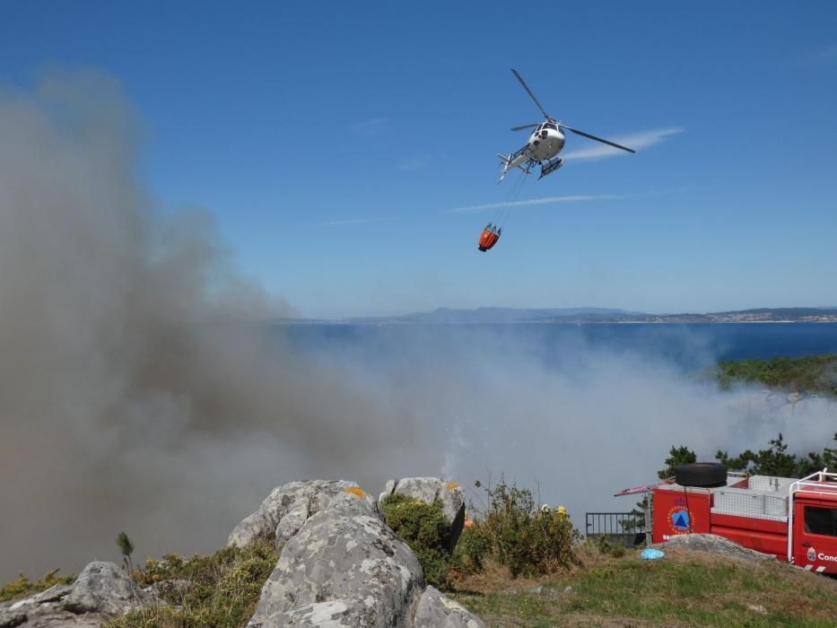 Las exhaustas labores de extinción del incendio de Cangas. // S. Álvarez