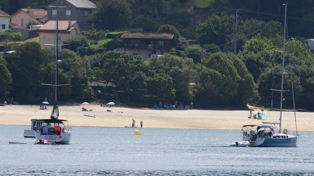 Embarcaciones de recreo con la playa de Arneles al fondo, dentro de la Ría de Aldán.