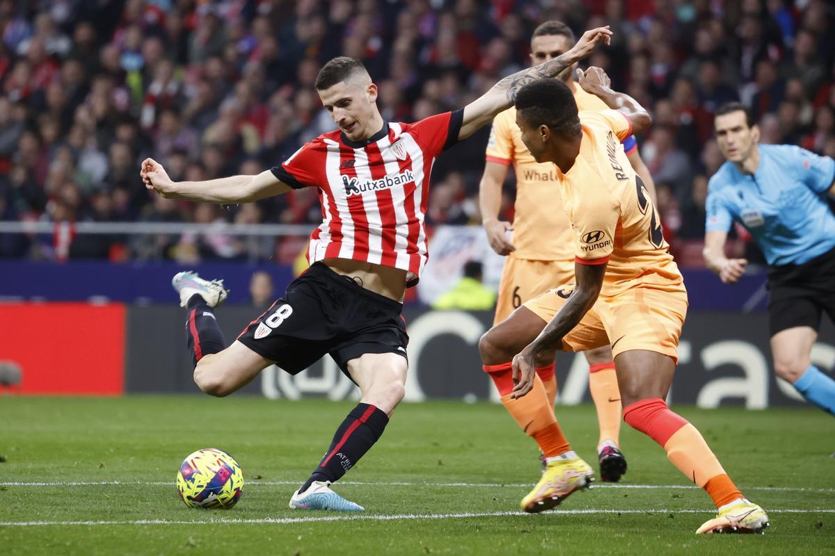 MADRID, 19/02/2023.- El centrocampista del Athletic Club, Oihan Sancet (i), se dispone a golpear el balón ante el centrocampista mozambiqueño del Atlético de Madrid, Reinildo Mandava, durante el encuentro correspondiente a la jornada 22 que disputan hoy domingo en el estadio Metropolitano, en Madrid. EFE / Juan Carlos Hidalgo.