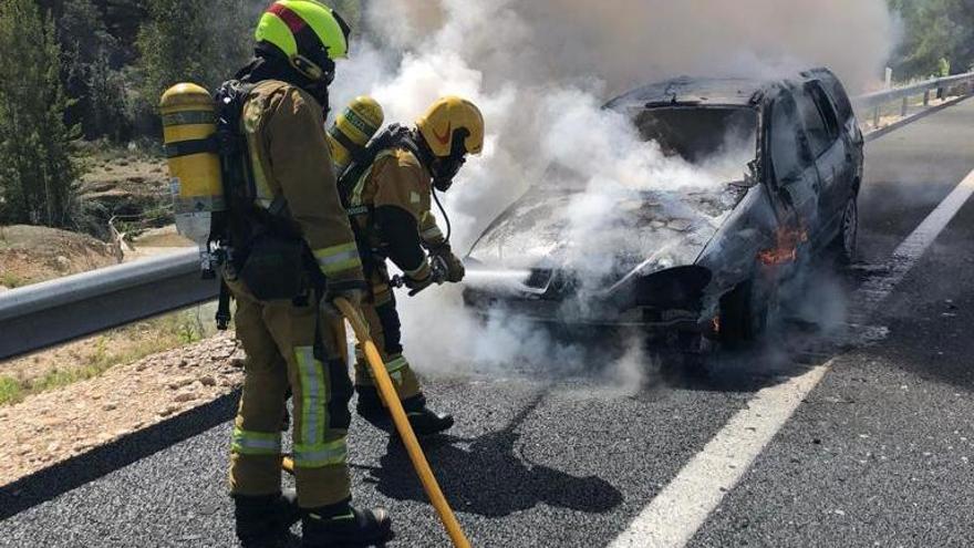 Los bomberos en plena intervención para extinguir el fuego que afectaba al vehículo