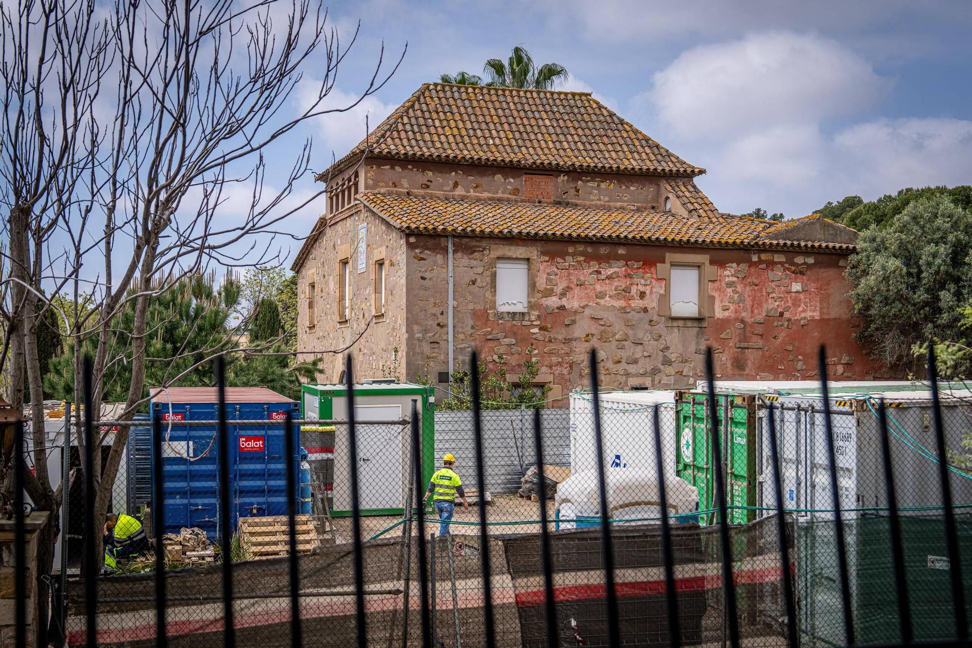 La Masia del Barça, tras unas casetas de obras de operarios de la reforma del Camp Nou.