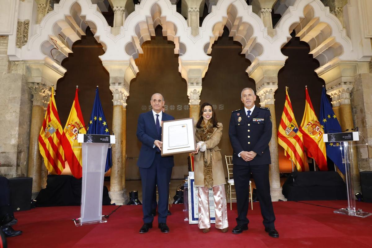 La presidenta de las Cortes entrega la distinción a la Policía Nacional.