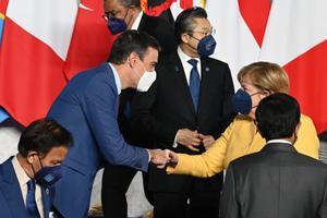 El presidente del Gobierno, Pedro Sánchez (i), saluda a la canciller de Alemania, Angela Merkel (d), durante la cumbre del G20, que se celebra este sábado en Roma.