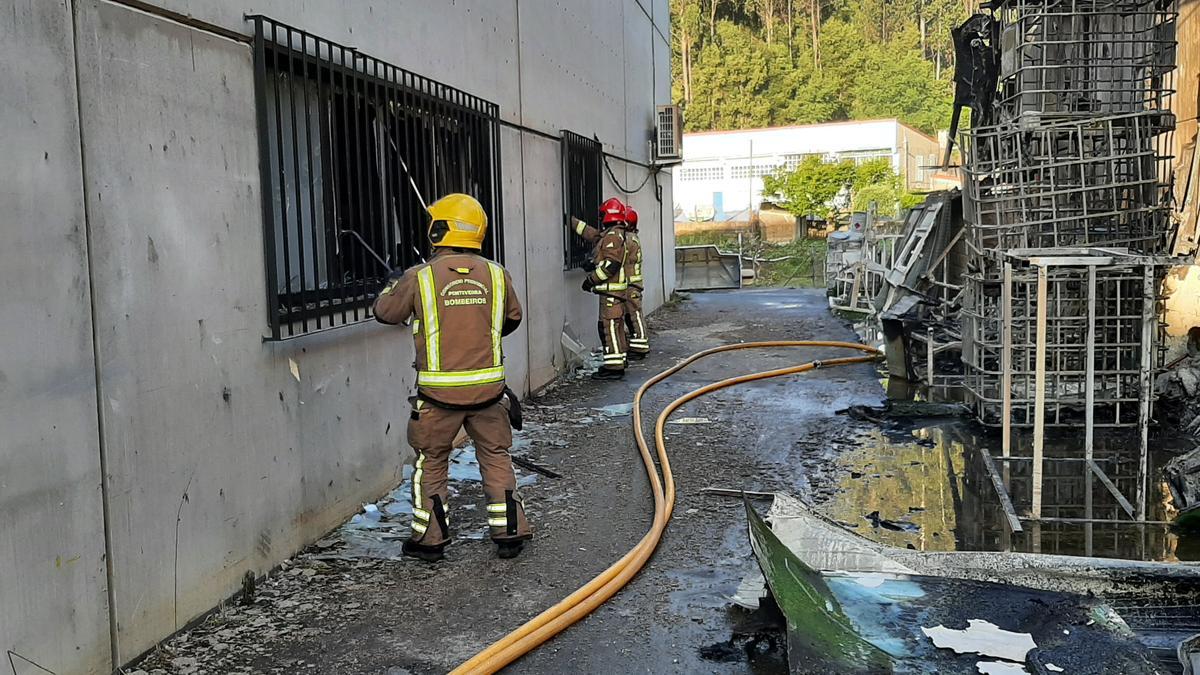 Los bomberos retiran los cristales rotos en la nave de Corvus Belli debido a la intensa temperatura.