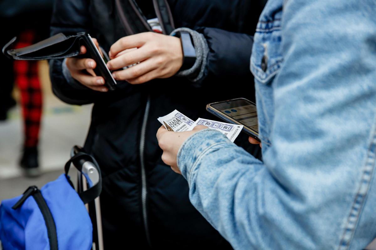 Una persona sostiene dos décimos del Sorteo Extraordinario del Niño.