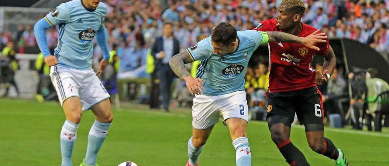 Hugo Mallo, junto a Radoja, frena a Paul Pogba, en el duelo entre el Celta y el United del pasado jueves. // Marta G.Brea