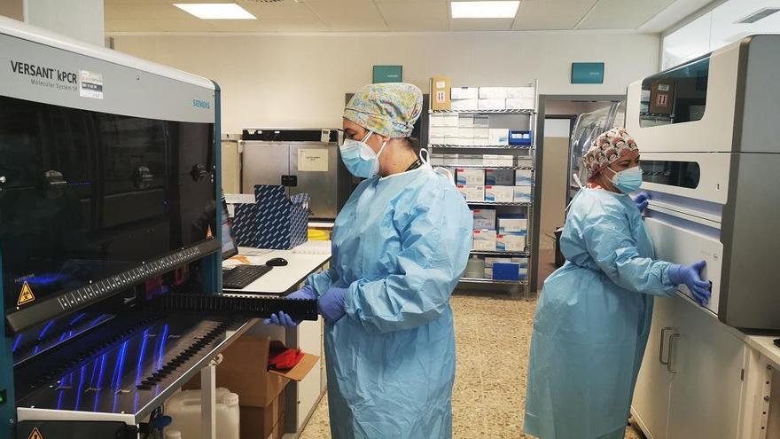 Dos técnicos trabajan con los nuevos robots para pruebas PCR del Hospital Costa del Sol.