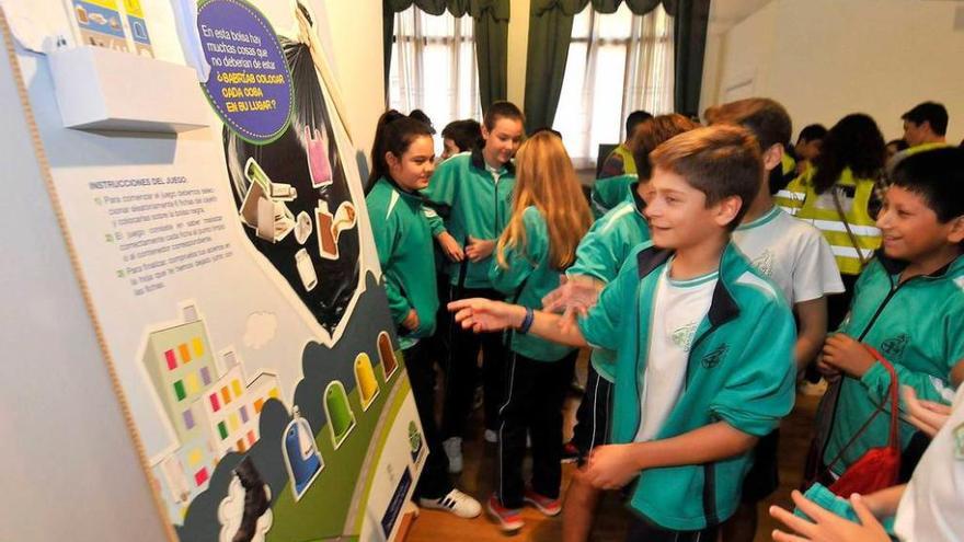 Los jóvenes langreanos, visitando ayer la exposición &quot;No te quedes atrás, separa tus residuos&quot;.