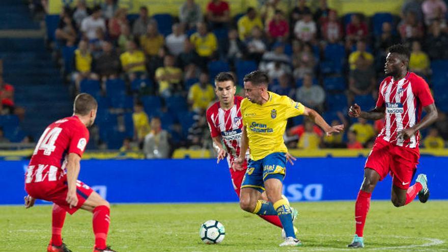 Hernán conduce un balón perseguido por Correa y Thomas.