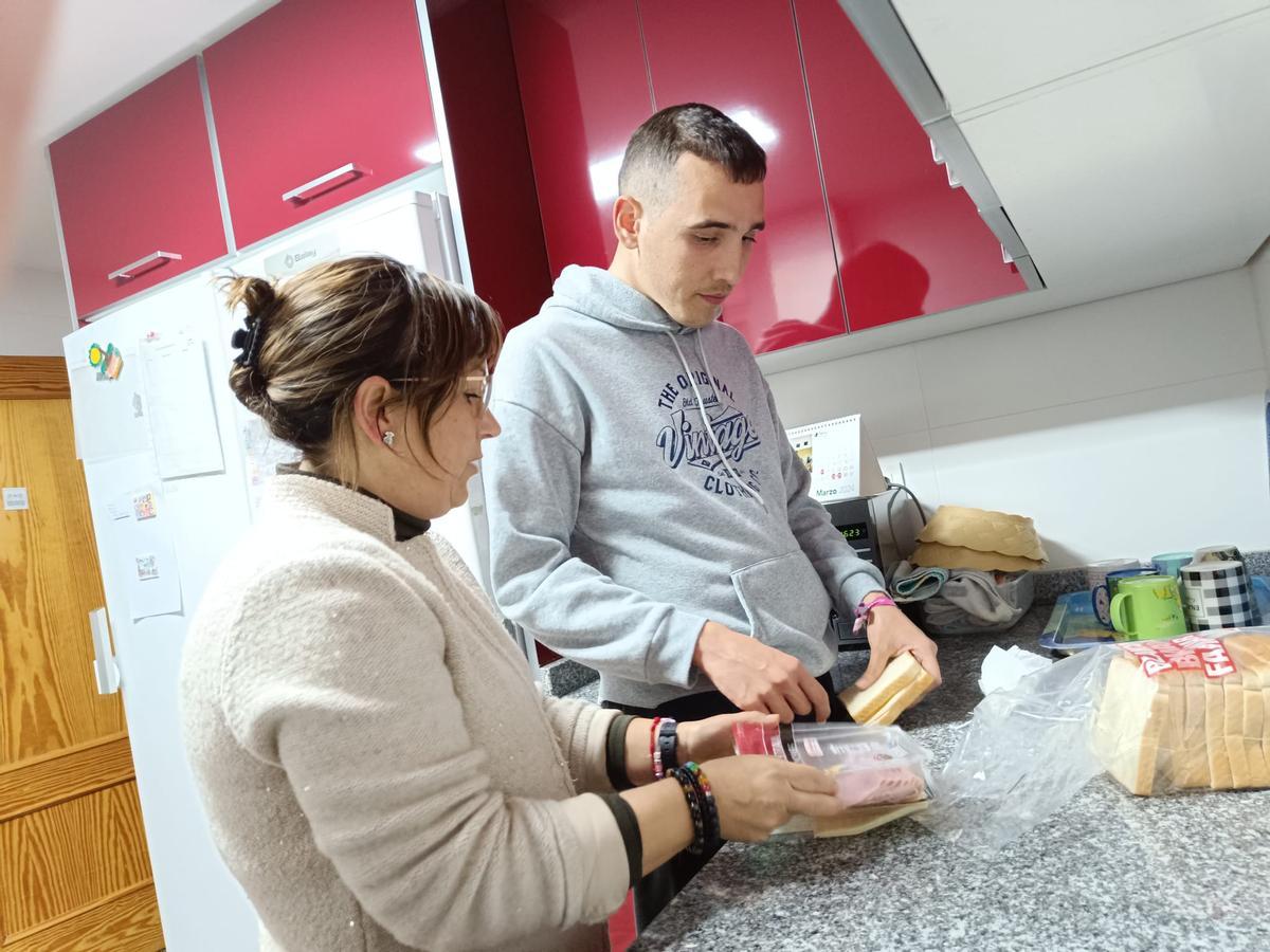 Ana Belén, persona de apoyo, ayuda a Mario a prepararse la merienda.