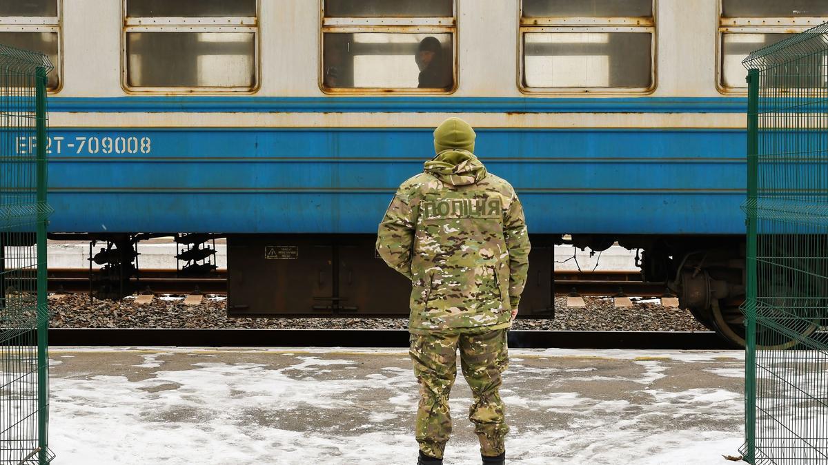 Un soldado ucraniano espera un tren en la nieve.