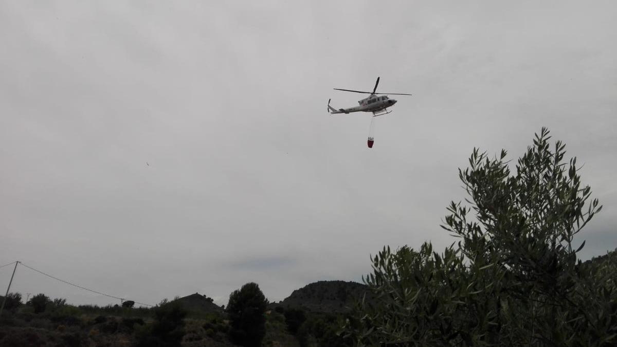 El helicóptero que ha intervenido en las labores de extinción del fuego, sobrevolando la zona