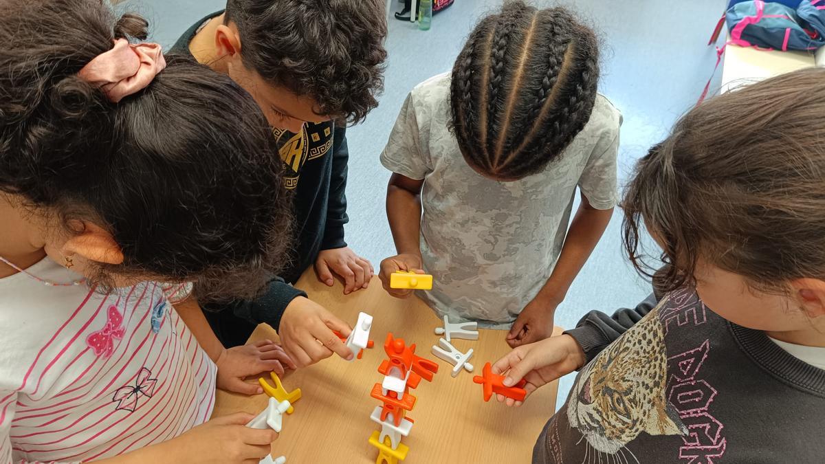 Alumnes amb el castell on aniran afegint castellers en la iniciativa de l'Escola Serra i Húnter per promoure el català