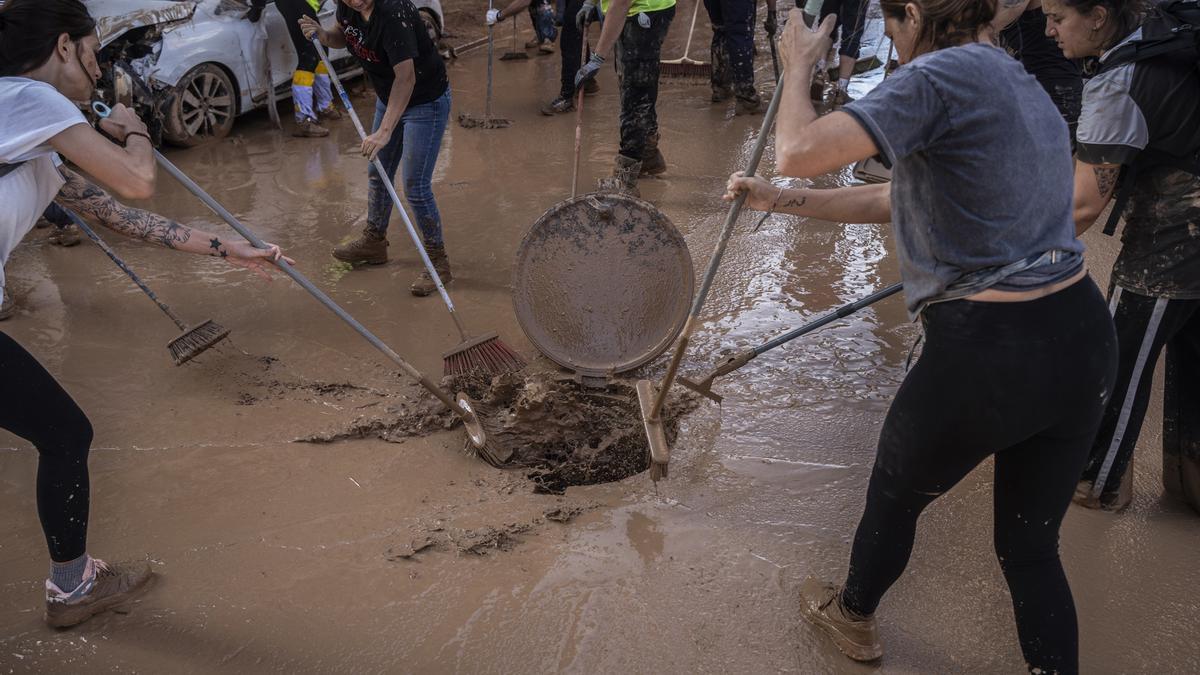 Varias personas limpian los estragos ocasionados por la DANA