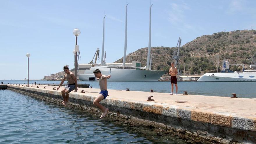 Tres niños se lanzan al agua en el puerto de Cartagena