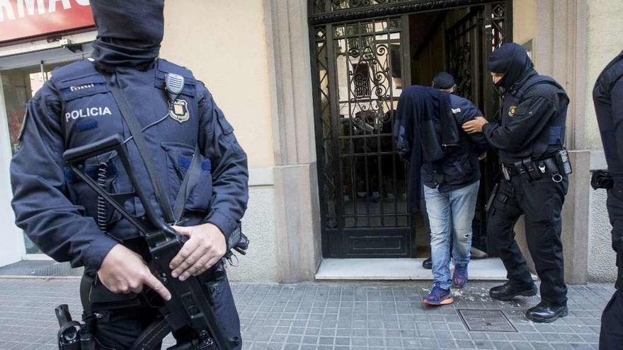 La Policía se lleva detenido a uno de los presuntos yihadistas arrestados ayer en Barcelona. // Efe