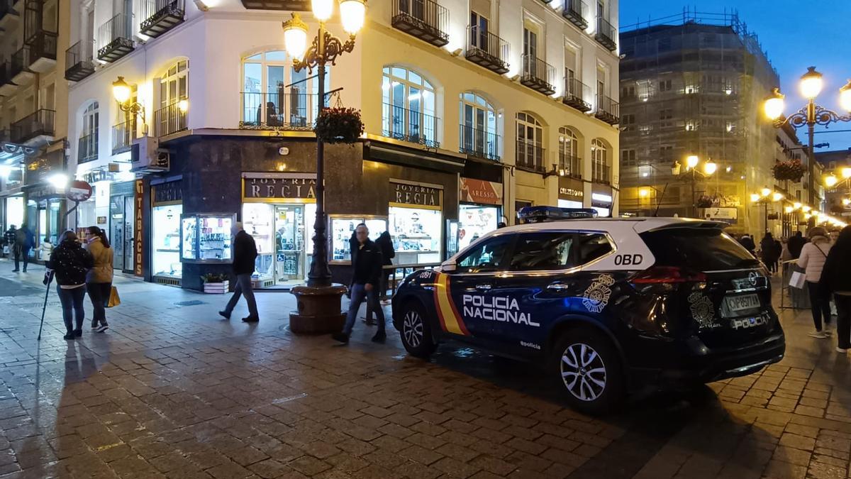 Un coche patrulla en medio de la calle Alfonso I, junto a la joyería Regia.