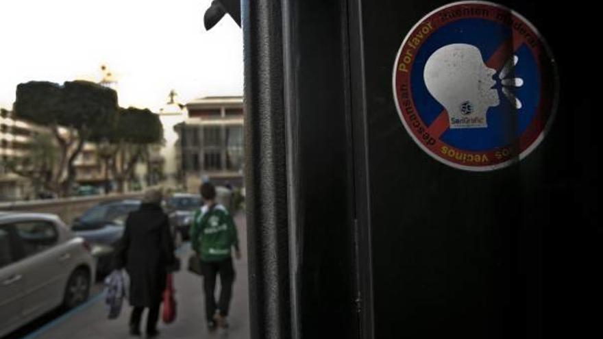 Un cartel en el que se solicita que se modere el ruido en el exterior de un establecimiento del centro.