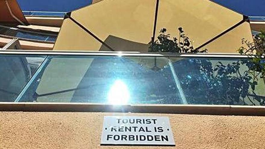 Cartel contra el alquiler turístico en un bloque de apartamentos de Platja d&#039;en Bossa.