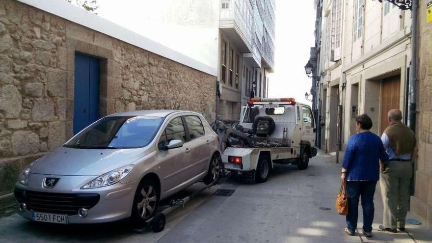 La grúa se lleva un coche aparcado indebidamente en la Ciudad Vieja. carlos pardellas