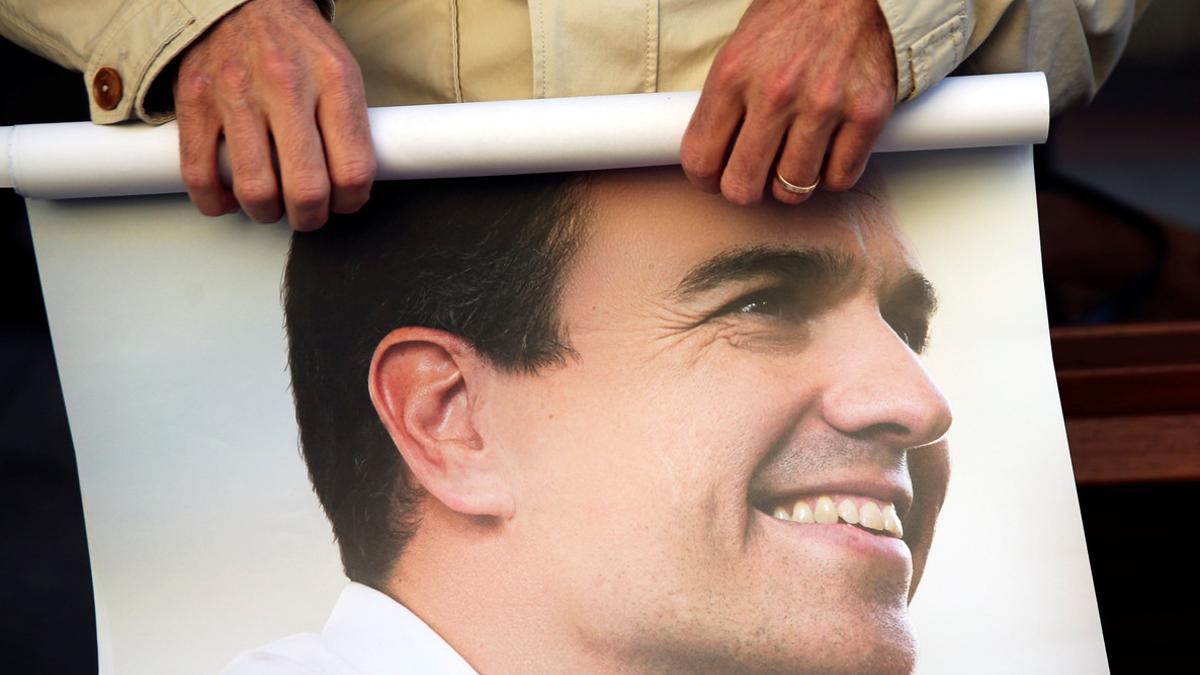 Un seguidor de Sánchez enrolla un cartel del ya exsecretario general del PSOE.