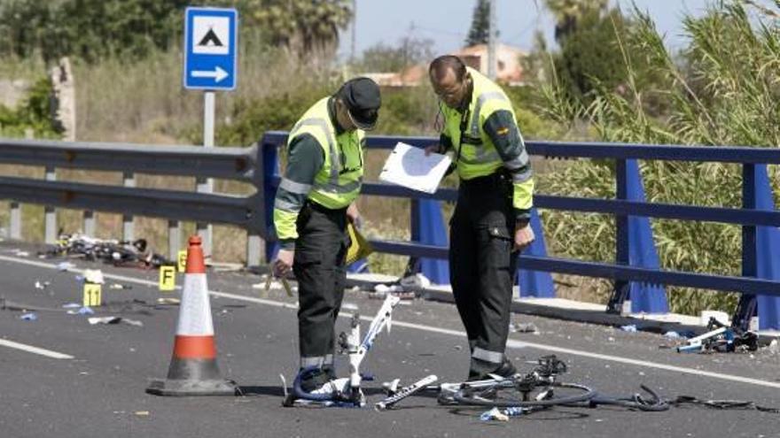 Dos guàrdies civils inspeccionen les restes de les bicicletes dels ciclistes atropellats.