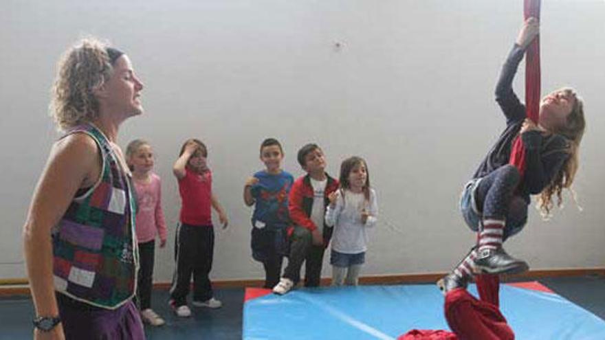 Andrea Floriach anima a una de las niñas a trepar por las telas.