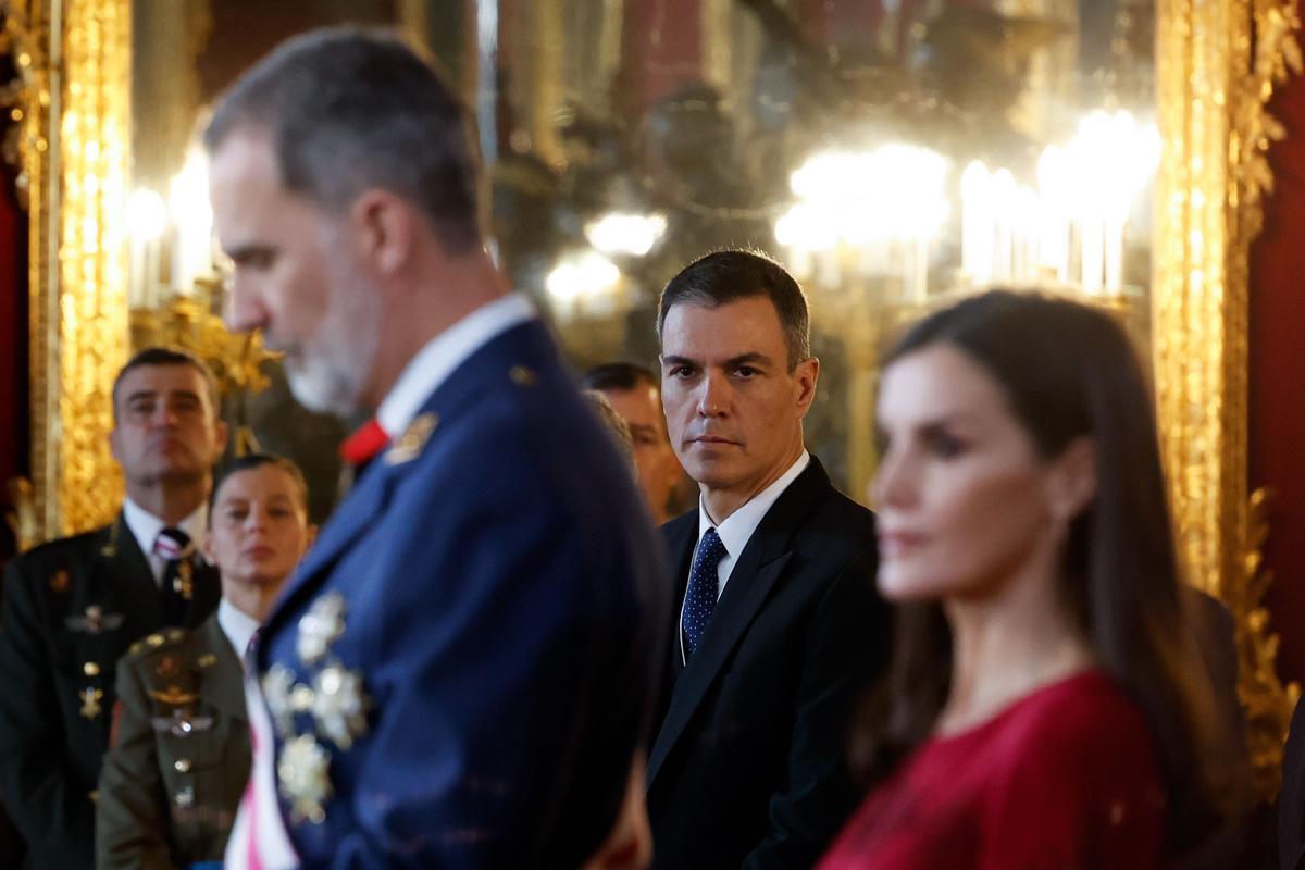 El presidente del Gobierno, Pedro Sánchez (C), escucha la intervención del rey Felipe VI (i), ante la reina Letizia, durante la celebración de la Pascua Militar este viernes en el Palacio Real de Madrid.