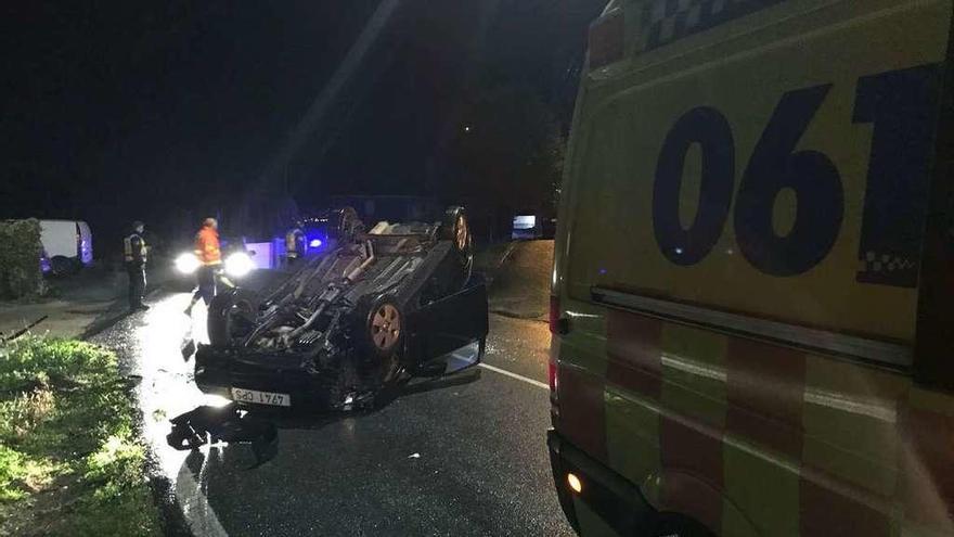 El coche volcado en la PO-315 y la ambulancia del 061 de Bueu. // Faro