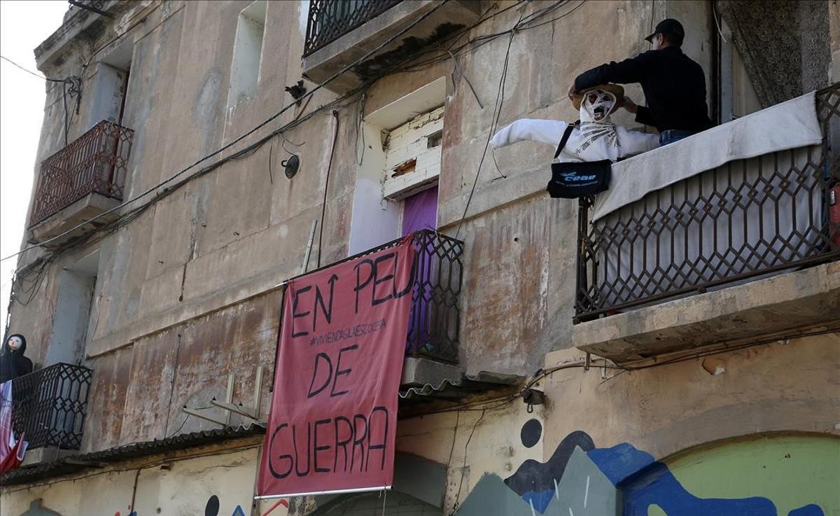 Un hombre coloca un muñeco en uno de los balcones de La Escocesa.