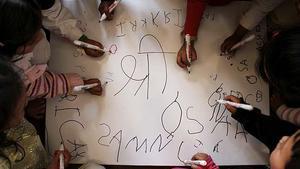 Un grup de nens escriuen lletres en una cartolina durant la commemoració del festival Bsant Panchmi, en un jardí infantil a Kàtmandu (Nepal). Els estudiants nepalesos visiten els temples durant aquest dia per rendir culte a la deessa Saraswati, muller de Brahma, deessa de l’aprenentatge i la saviesa.