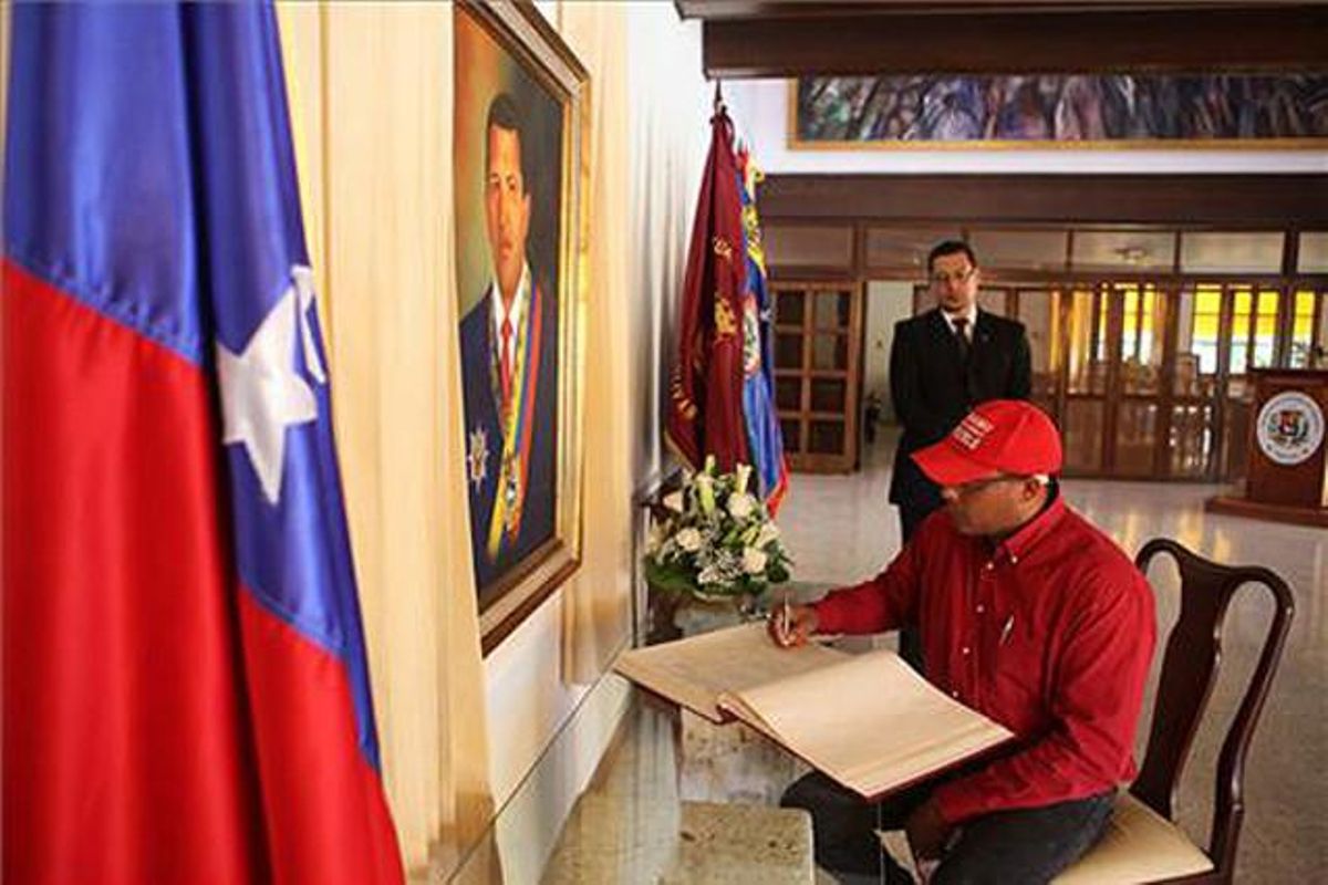Un home firma el llibre de condolences a l’ambaixada de Veneçuela de Santo Domingo (República Dominicana).