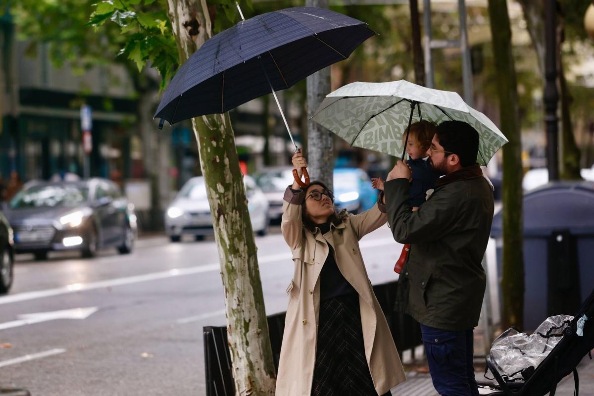 Una familia bajo la lluvia en Córdoba este sábado.