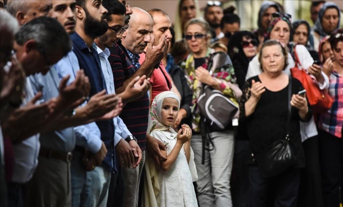 Los familiares de una azafata que murió durante el bombardeo del aeropuerto Ataturk rezan en su funeral.