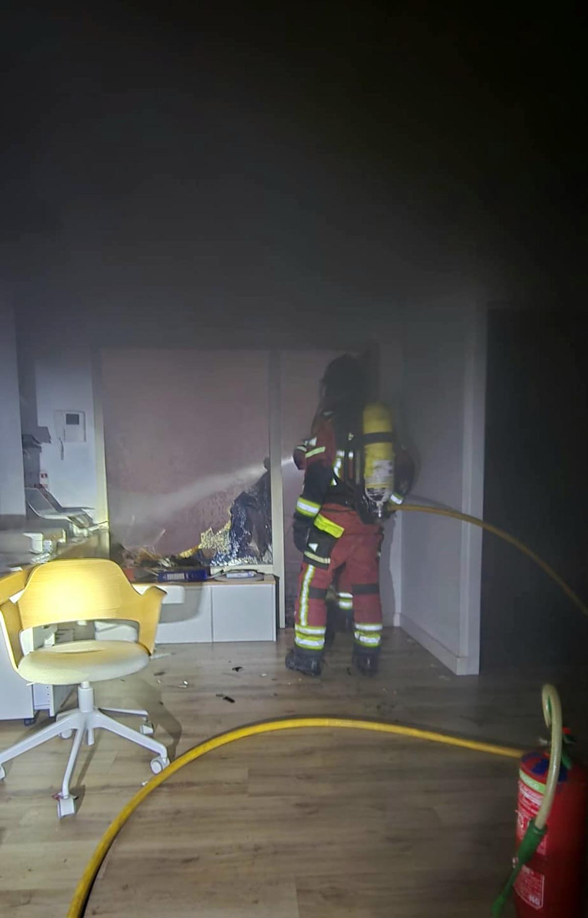 Un bombero, en el interior de la vivienda afectada por las llamas en Las Canteras