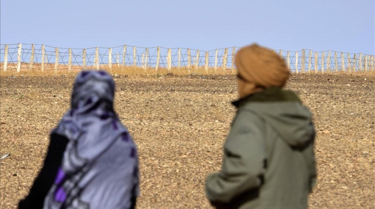 Zghala, una mujer del Sáhara Occidental, mira hacia la valla en el área de Al-Mahbes, mientras acompaña a su hijo de 14 años para mostrarle el muro que separa Marruecos de la zona controlada por el Polisario, el 3 de febrero del 2017.