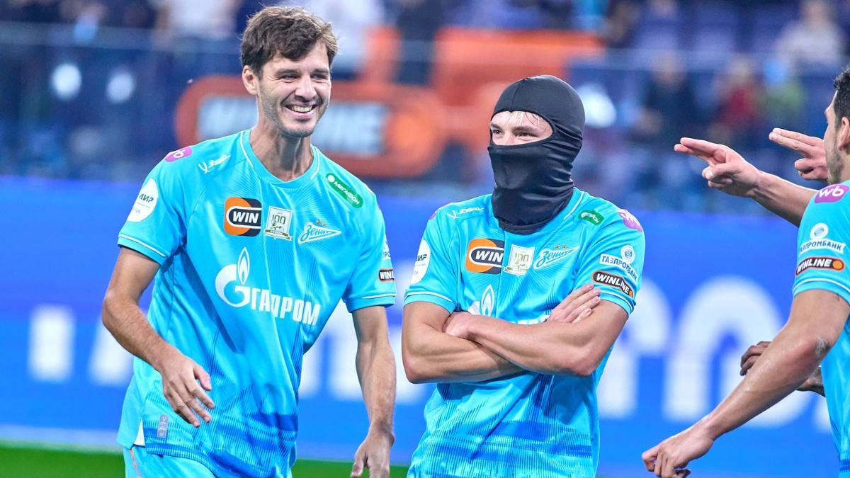 Erokhin sonríe junto a Mostovoy, mientras dos compañeros similar apuntar con una pistola