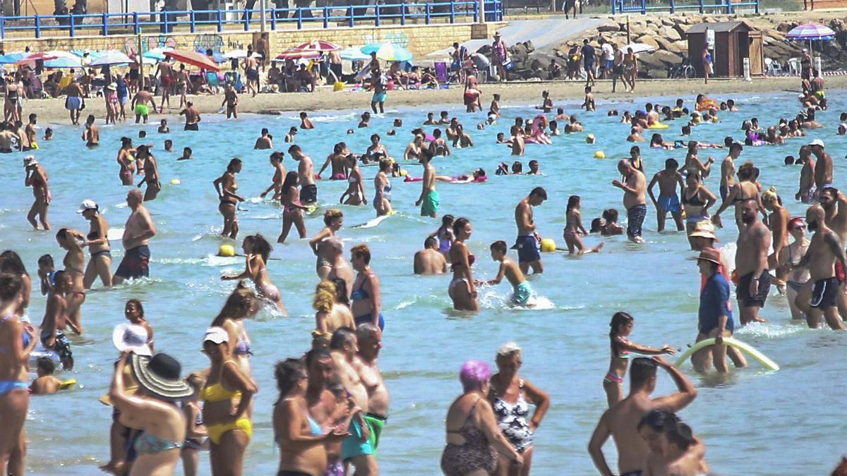 En playa del Postiguet de Alicante es complicado hasta encontrar sitio en el agua.  | PILAR CORTÉS