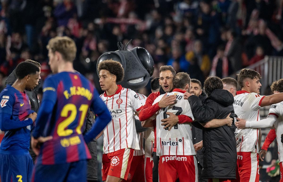 Los jugadores del Girona se felicitan tras la victoria sobre el Barça ante la decepción blaugrana.
