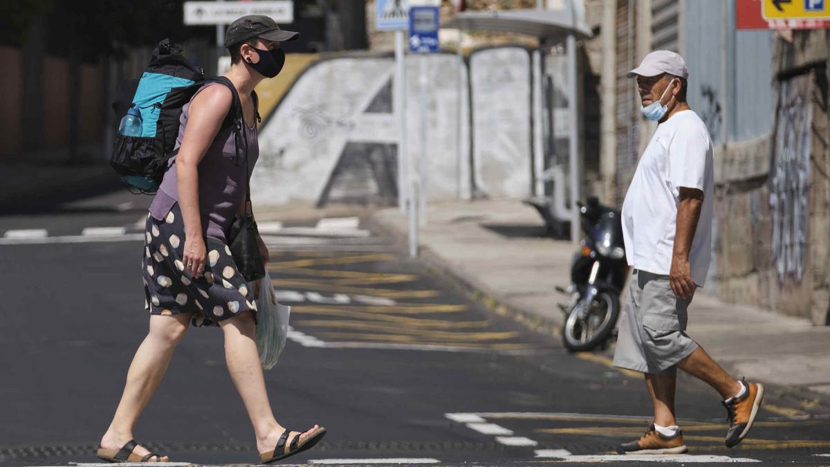 Varias personas con mascarilla caminan por Santa Cruz de Tenerife.