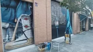 Un artista realiza un grafiti en la calle Sagasta de Murcia en honor al Cristo del Amparo