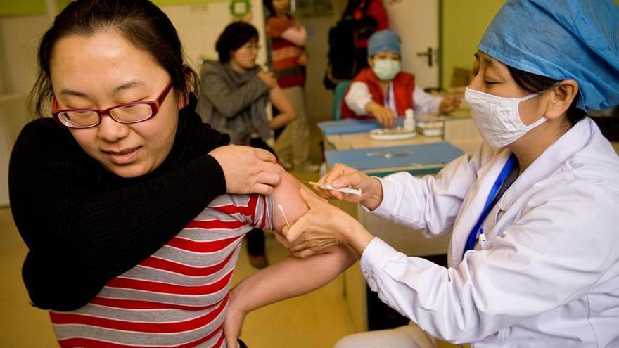 Una sanitaria inyecta a una vacuna a una mujer en China.