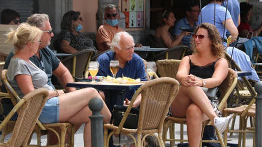 Un grup de persones prenent un beure a una terrassa de Palamós